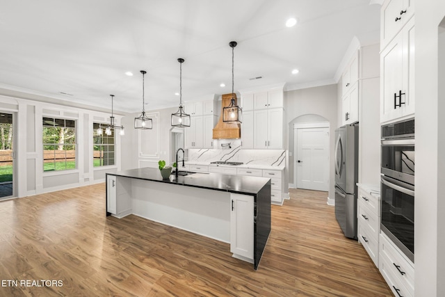 204 Atoka Pl, Loudon, TN 37774 - kitchen with appliances with stainless steel finishes, light wood-style floors, white cabinetry, a center island with sink, and decorative backsplash
