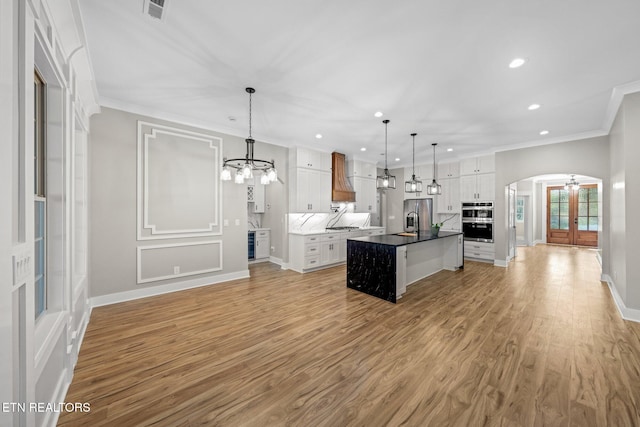 204 Atoka Pl, Loudon, TN 37774 - kitchen featuring arched walkways, a notable chandelier, white cabinetry, and custom exhaust hood