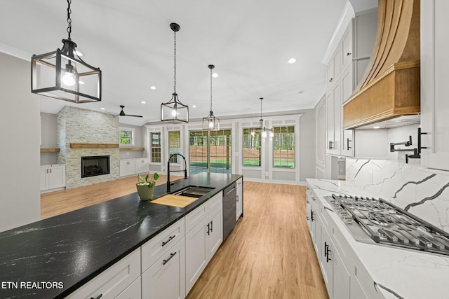 204 Atoka Pl, Loudon, TN 37774 - kitchen with ceiling fan, a fireplace, white cabinetry, a sink, and stainless steel appliances