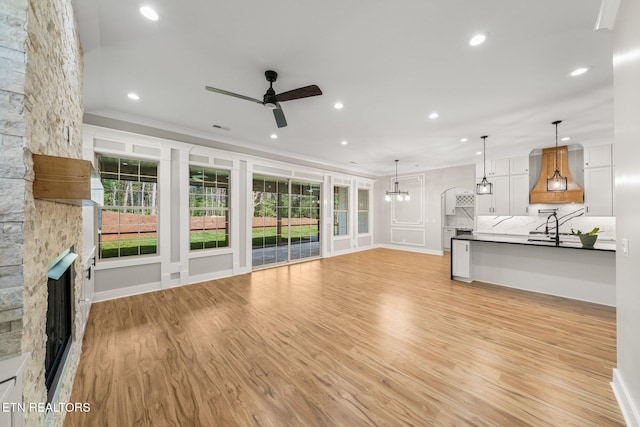 204 Atoka Pl, Loudon, TN 37774 - unfurnished living room with a healthy amount of sunlight, light wood-style floors, a stone fireplace, and ceiling fan
