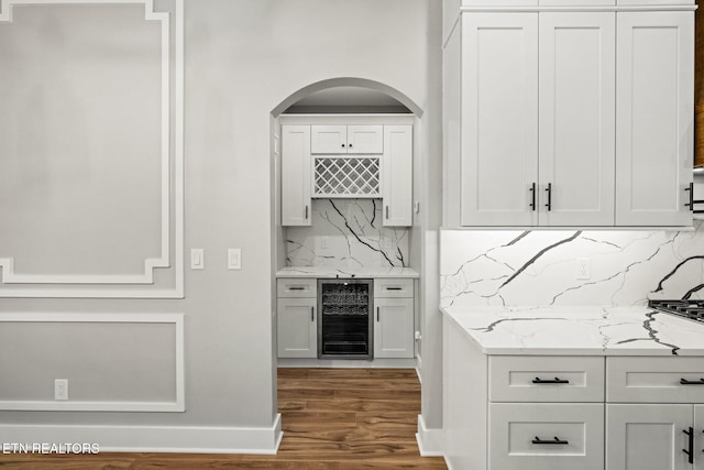 204 Atoka Pl, Loudon, TN 37774 - bar with baseboards, arched walkways, wood finished floors, decorative backsplash, and beverage cooler