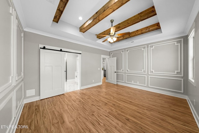 204 Atoka Pl, Loudon, TN 37774 - unfurnished bedroom featuring light wood-type flooring, ornamental molding, a barn door, beam ceiling, and a decorative wall