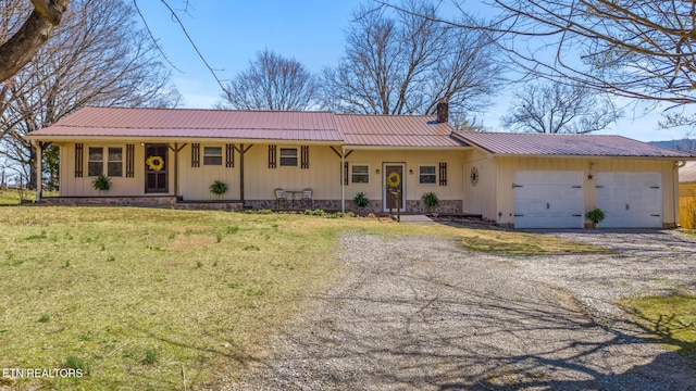 ranch-style home featuring metal roof, gravel driveway, an attached garage, a chimney, and a front yard