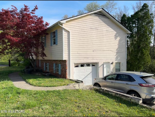 view of property exterior with an attached garage, brick siding, and a yard