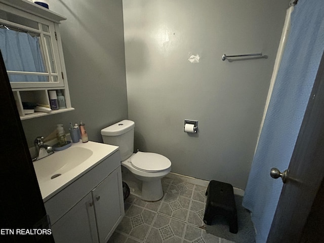 bathroom featuring baseboards, toilet, vanity, and tile patterned floors