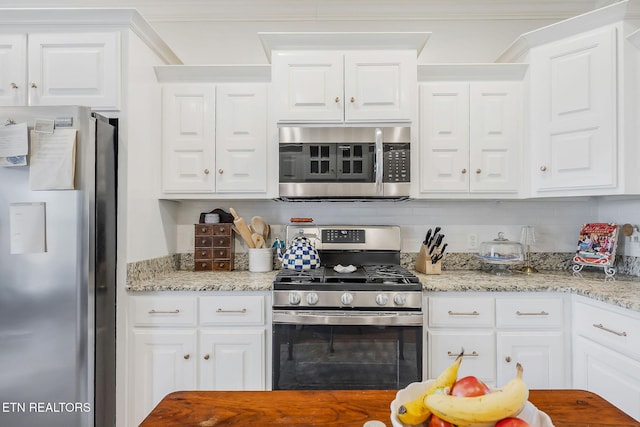 1798 Pearl Ave, Cookeville, TN 38506 - kitchen featuring light stone counters, appliances with stainless steel finishes, white cabinets, decorative backsplash, and ornamental molding