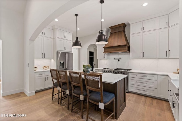 788 Blackberry Ridge Rd, Lenoir City, TN 37772 - kitchen featuring arched walkways, high quality appliances, premium range hood, and light wood-style floors
