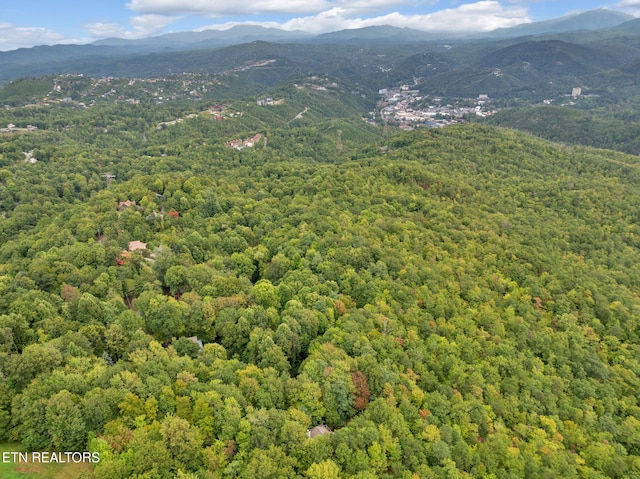 aerial view with a wooded view and a mountain view