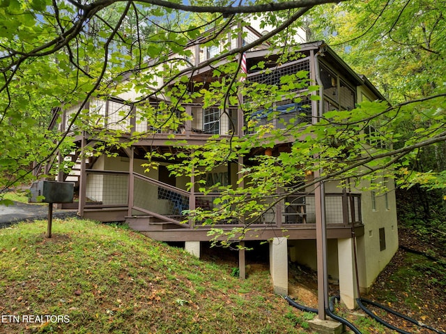 view of home's exterior with stairs and a wooden deck