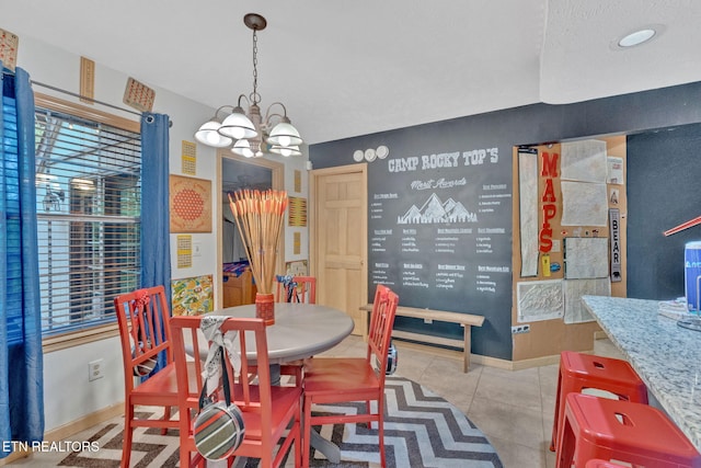 dining space with tile patterned floors, an inviting chandelier, and baseboards