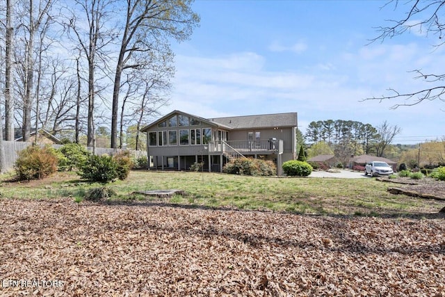 back of house featuring a yard, fence, a deck, and stairway