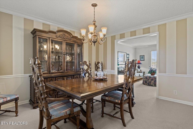 dining area with an inviting chandelier, a textured ceiling, ornamental molding, light carpet, and baseboards
