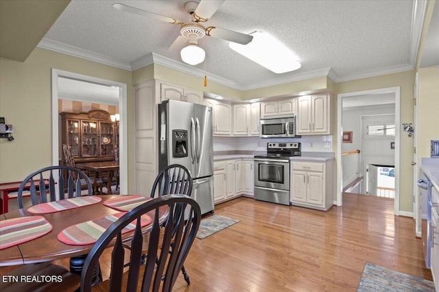 kitchen with light countertops, light wood finished floors, ceiling fan, and stainless steel appliances