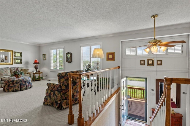 interior space with crown molding, a wealth of natural light, carpet flooring, and ceiling fan