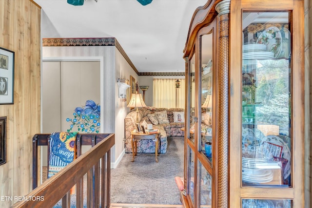 hall featuring ornamental molding and carpet