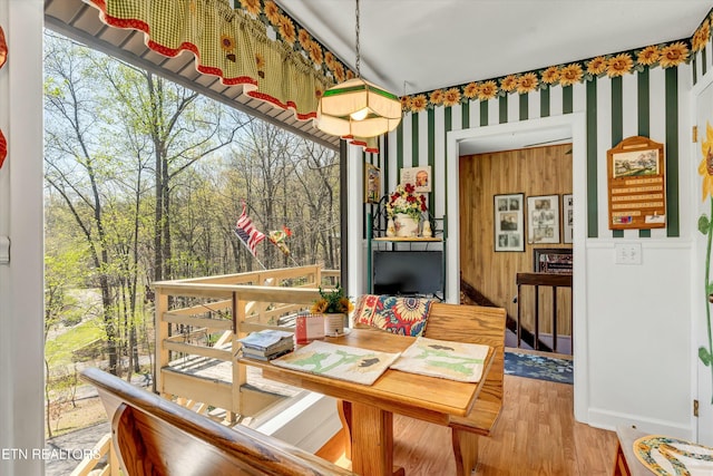 dining room featuring wallpapered walls and wood finished floors