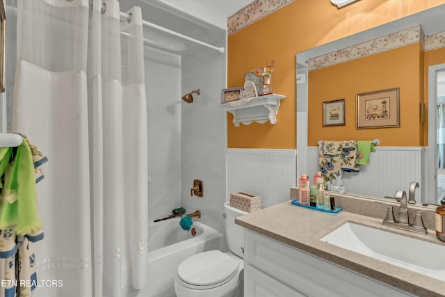 full bathroom featuring shower / tub combo, toilet, wainscoting, and vanity