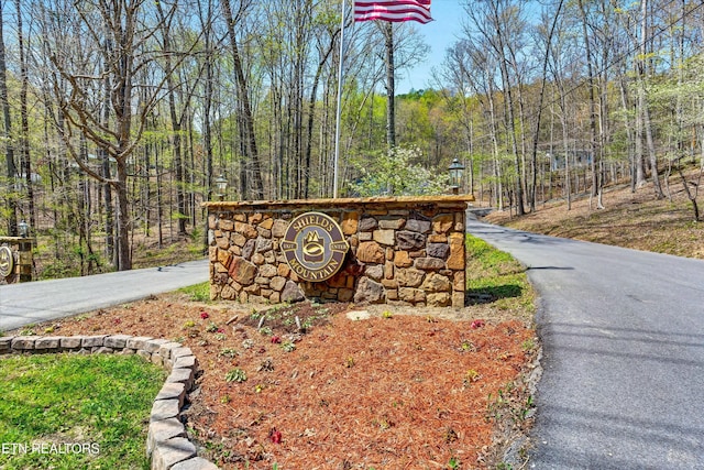 community sign featuring a view of trees