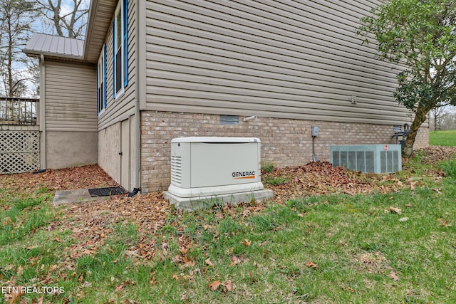 details featuring a power unit, central AC unit, and brick siding