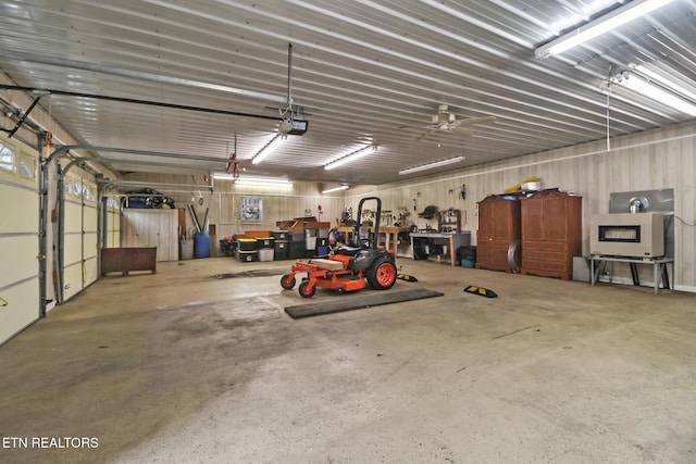 garage with a garage door opener, a workshop area, and metal wall