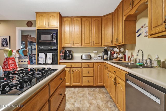 kitchen featuring a sink, light countertops, black appliances, and brown cabinets