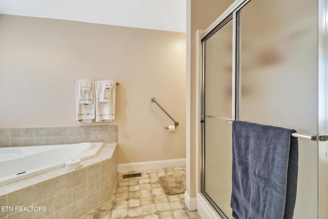 bathroom with a bath, baseboards, visible vents, and a stall shower