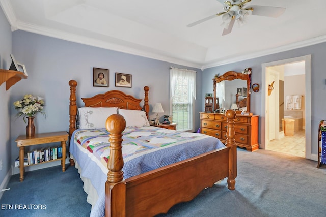 carpeted bedroom with baseboards, a raised ceiling, ornamental molding, ceiling fan, and ensuite bath