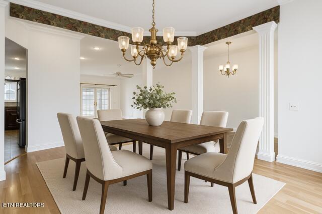 dining room featuring light wood-type flooring, baseboards, ceiling fan with notable chandelier, and ornate columns