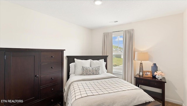 bedroom with carpet, visible vents, and baseboards