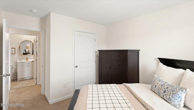 bedroom with light colored carpet and baseboards