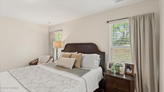bedroom featuring visible vents and multiple windows