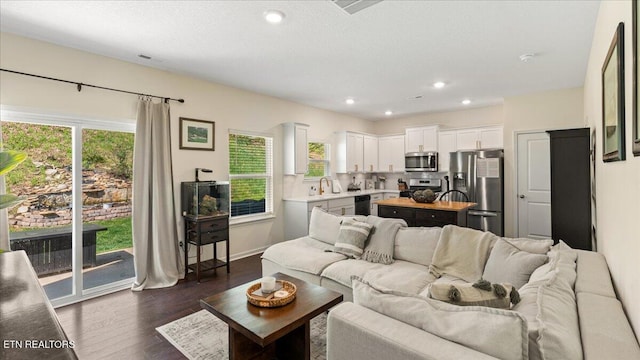 living area featuring recessed lighting and dark wood-style floors