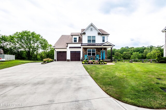 craftsman inspired home with a standing seam roof, a front lawn, concrete driveway, and fence