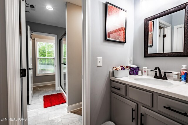 full bathroom featuring baseboards, a stall shower, and vanity