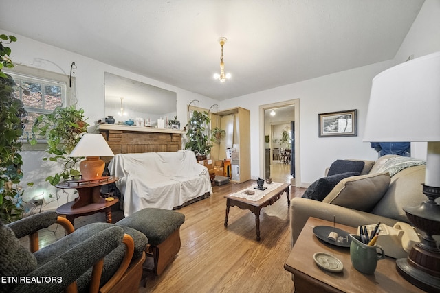 living room with light wood-style floors and a notable chandelier
