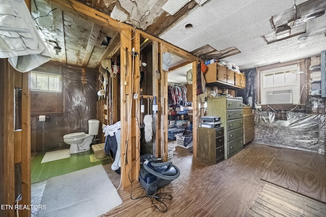 interior space featuring toilet, wood finished floors, and cooling unit