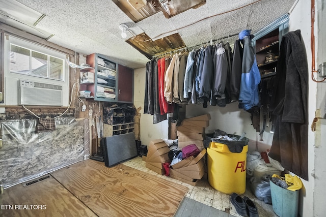 walk in closet featuring cooling unit, wood finished floors, and visible vents