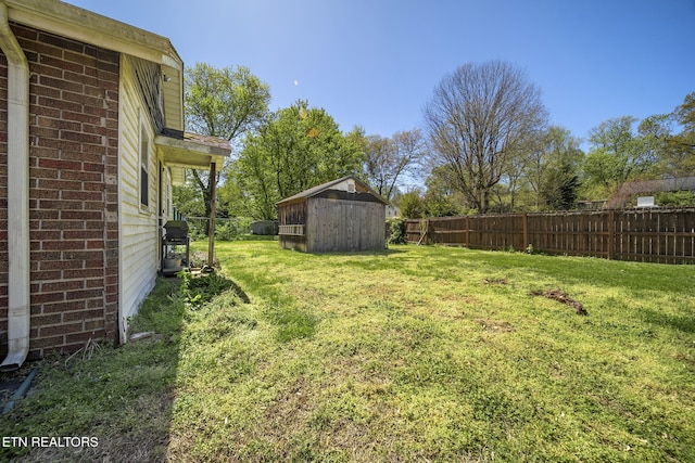 view of yard featuring fence, an outbuilding, and a shed