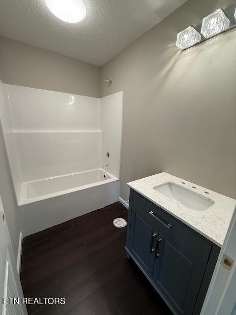 515 Hillcrest St, Clinton, TN 37716 - bathroom with wood finished floors, vanity, a textured ceiling, and shower / tub combination