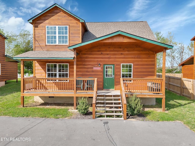 view of front of home with crawl space, a porch, roof with shingles, a front yard, and fence