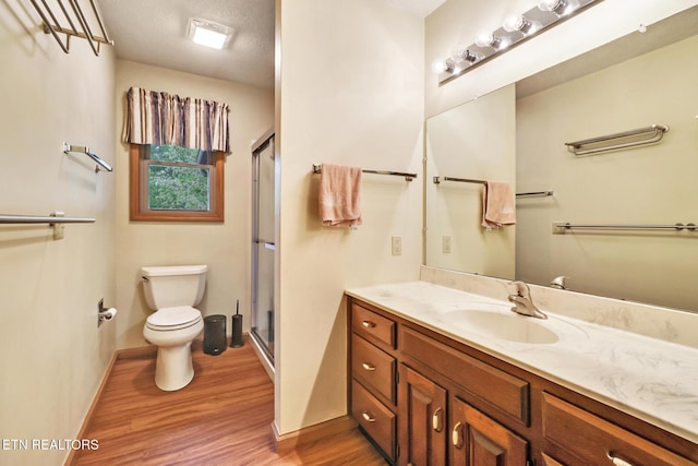 214 Snead Dr, Crossville, TN 38558 - full bathroom featuring toilet, wood finished floors, vanity, a stall shower, and baseboards
