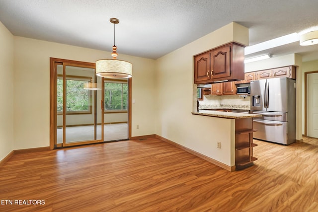 214 Snead Dr, Crossville, TN 38558 - kitchen with appliances with stainless steel finishes, baseboards, hanging light fixtures, a peninsula, and light wood-type flooring