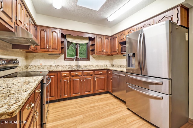 214 Snead Dr, Crossville, TN 38558 - kitchen with a sink, stainless steel appliances, light stone countertops, under cabinet range hood, and light wood-style floors
