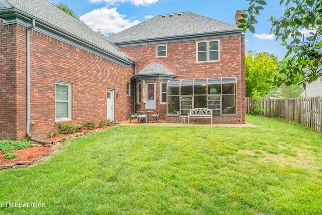 back of house featuring roof with shingles, brick siding, a fenced backyard, a chimney, and a lawn