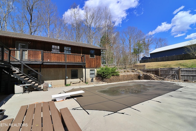 back of property featuring fence, stairway, a patio, and stucco siding