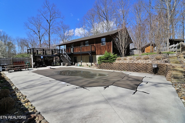 rear view of property with a patio, a wooden deck, fence, and stairs