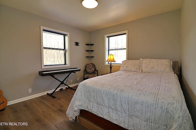 bedroom with dark wood-type flooring, baseboards, and multiple windows