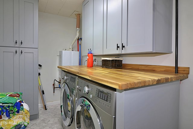 washroom featuring cabinet space and washer and clothes dryer