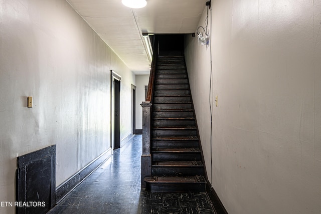 staircase featuring baseboards