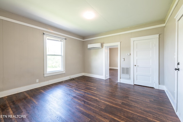 unfurnished bedroom with visible vents, baseboards, a wall mounted AC, and wood finished floors